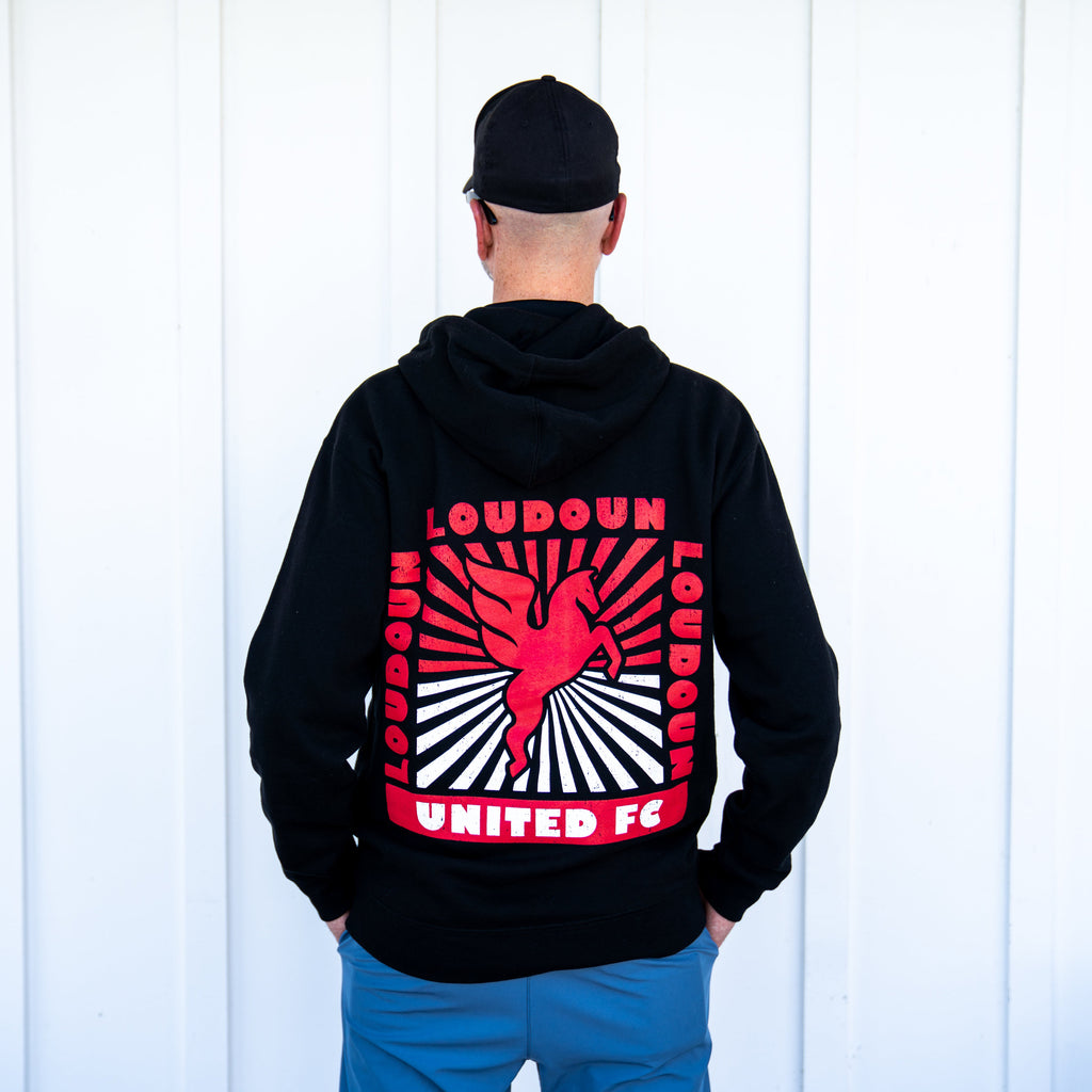 Person wearing a black hoodie with Loudoun United FC logo on the back against a white background